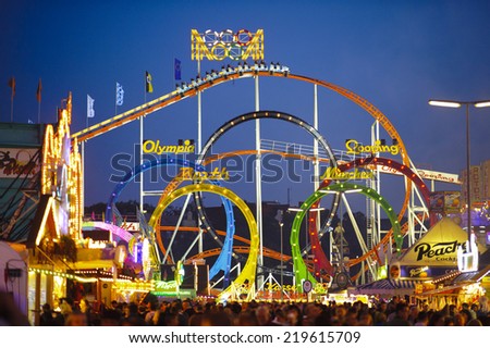 MUNICH, GERMANY - SEPTEMBER 23, 2014: The Oktoberfest in Munich is the biggest beer festival of the world. The visitors have lot of fun with many amusement huts and big carousels.