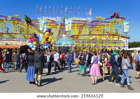 MUNICH, GERMANY - SEPTEMBER 23, 2014: The Oktoberfest in Munich is the biggest beer festival of the world. The visitors have lot of fun with many amusement huts and shops for food and souvenirs.