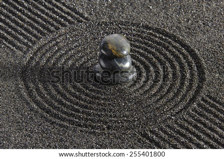 Japanese ZEN garden with stacked stones in black sand