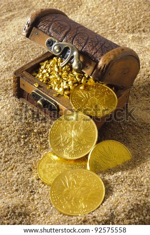 treasure chest with gold coins on sandy beach