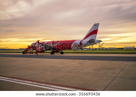 bangkok , Thailand - September 9 ,2015 : airplane of thai airasia park on runway with beautiful sunrise scene on 9 September 2015