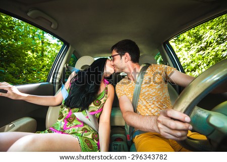 Young Couple Driving Along Country Road.
