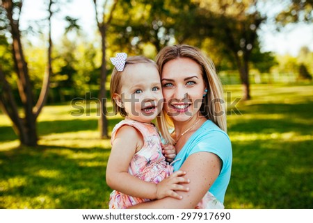Happy mom and daughter smiling at nature.