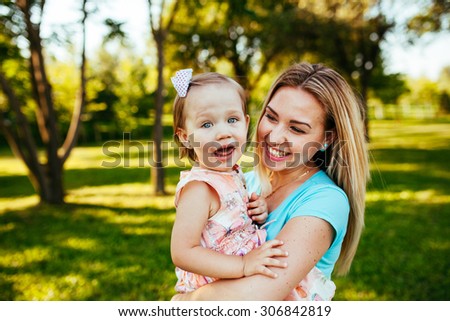 Happy mom and daughter smiling at nature.