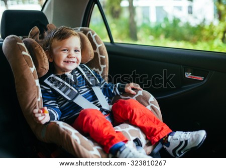 Adorable baby boy in safety car seat.
