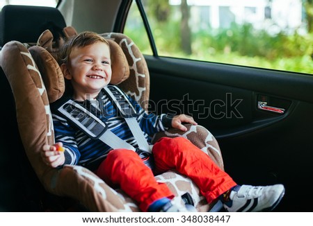 Adorable baby boy in safety car seat.
