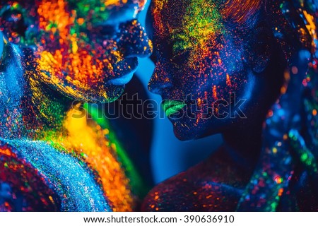 People are colored fluorescent powder. a pair of lovers dancing at a disco.