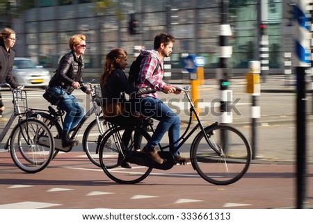 Amsterdam,Netherlands - October 31, 2015: Panning shot of a man on bicycle with his girlfriend at the back of bicycle on the street in Amsterdam, Netherlands