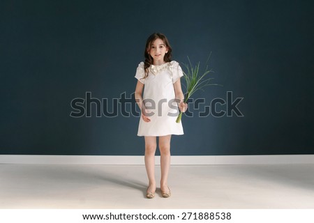 Full length portrait of a happy little girl on dark background.
