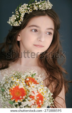 Portrait of a funny little girl with bouquet of white and orange flowers