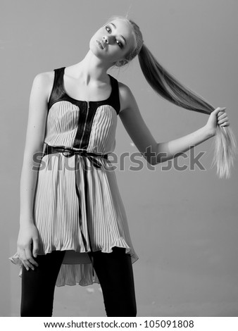 A teenager girl holding her long blonde strong hair