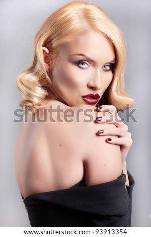 Sensitive portrait of a blonde woman with curling hair. Studio shot
