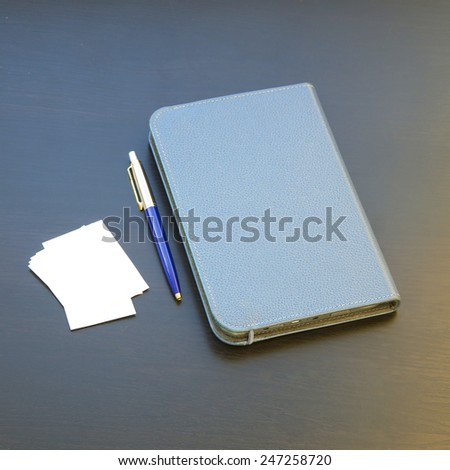 notebook, pen and white stickers. on black background
