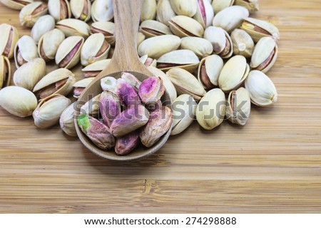 Roasted Pistachio nut in wood spoon on wood background