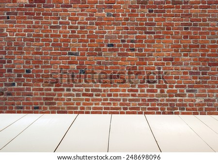 Grungy textured red brick wall with white wooden floor inside