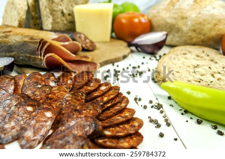 Healthy vegetables and sirloin and sausage on a wooden white tab