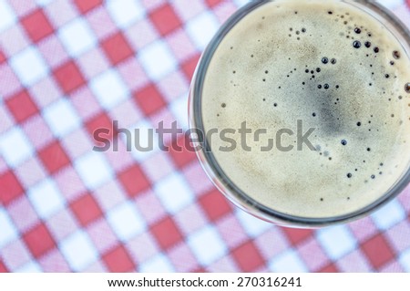 Beer glass on red and white vintage tablecloth background -  Beer style pictures