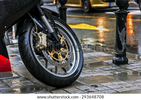 Large motorcycle leaning on its stand in the rain in the city