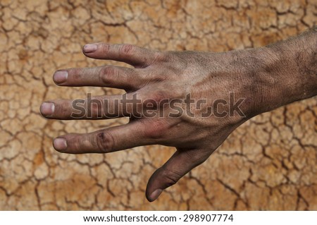 Farmer\'s rough hand isolated on fertile soil