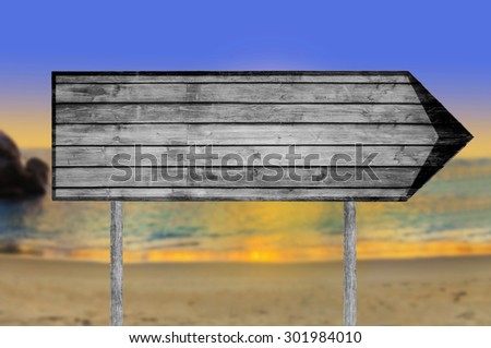 Empty wooden sign with a beach on background