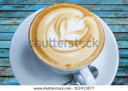 Cup of freshly made espresso in coffee shop on blue wood board