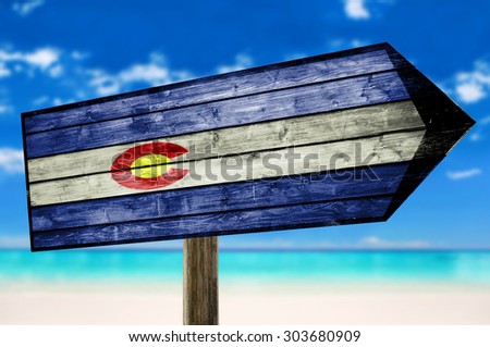 Colorado Flag on wooden table sign on beach background