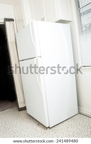 Simple white refirgerator and freezer on corner of kitchen