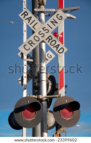 Stop lights at rail crossing under bright blue sky
