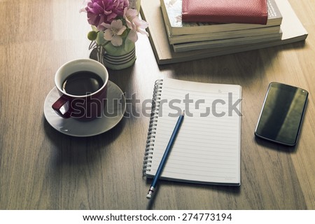office working desk top view with book, smartphone, notepad and coffee cup - vintage style