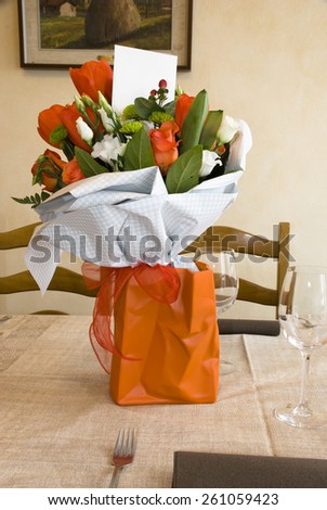 photo of the vase of flowers on the table set