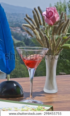 The aperitif on the table with the vase of flowers and the book and feather to write