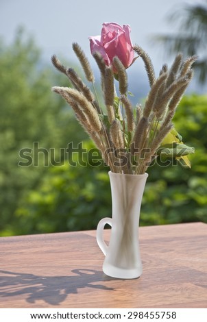 the vase of flowers with pink ears