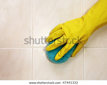 Cleaner is cleaning tiles in bathroom