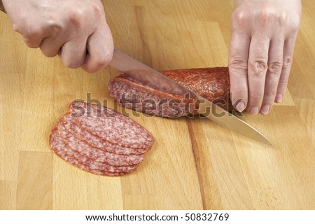 stock-photo-woman-cutting-sausage-by-knife-50832769.jpg