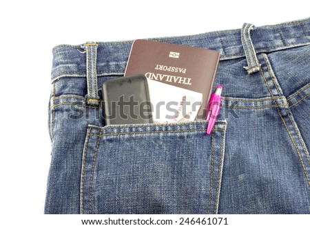 Closeup of passport and old mobile phone money pen in blue jeans pocket