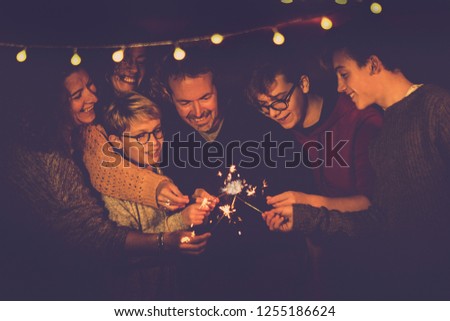 Night party celebration like new year eve 2019 or Christmas for caucasian big modern family using sparkles light fireworks together in friendship having fun - people smiling and do party