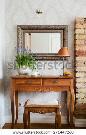 Classical dressing table and a mirror and a pot of blue bells