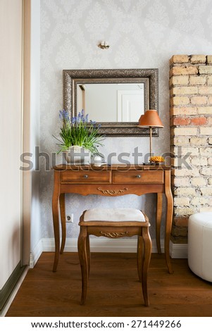 Classical dressing table and a mirror and a pot of blue bells