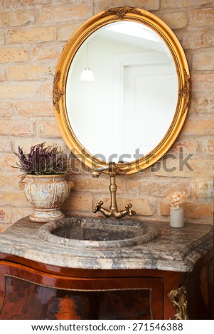 Vintage bathroom with a marble sink, brass faucet and a mirror