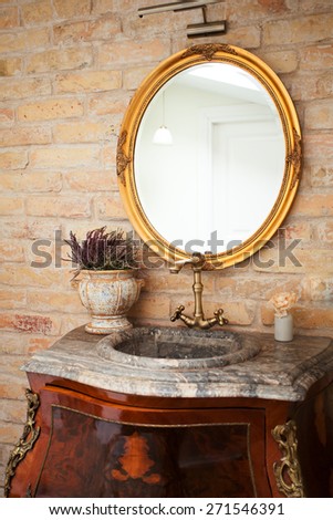 Vintage bathroom with a marble sink, brass faucet and a mirror