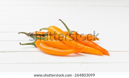 Yellow chili pepper on white table background