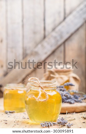 lavender honey in glass jars on wooden table. rural style