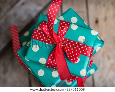 gifts in a beautiful and elegant package on the wooden table. red and turquoise colors. polka dots. top view