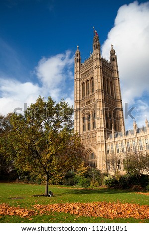 Side view on the British Parliament with a large meadow with green grass