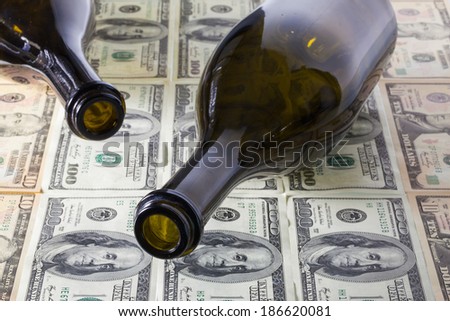 Two empty wine bottle and US dollar banknotes