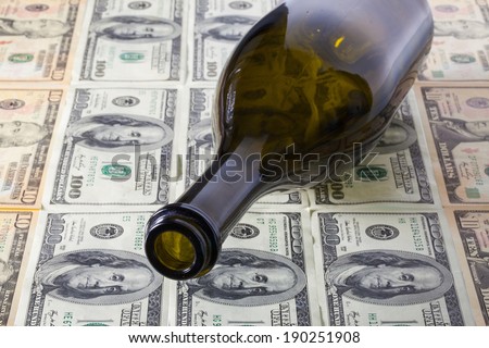 Empty wine bottle and US dollar banknotes
