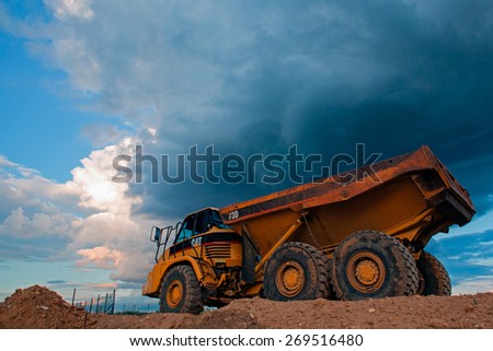 Prague, Czech Republic  - June 14,2011:Yellow Cut truck on the highway construction before heavy storm. The Cat brand is the cornerstone of the Caterpillar brand portfolio.