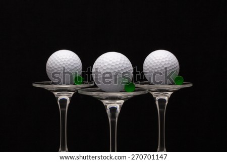 Three glasses of champagne with golf balls