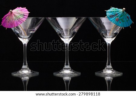Three empty glasses of champagne with decoration (paper umbrellas).