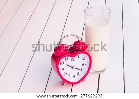 alarm clock and milk in a glass